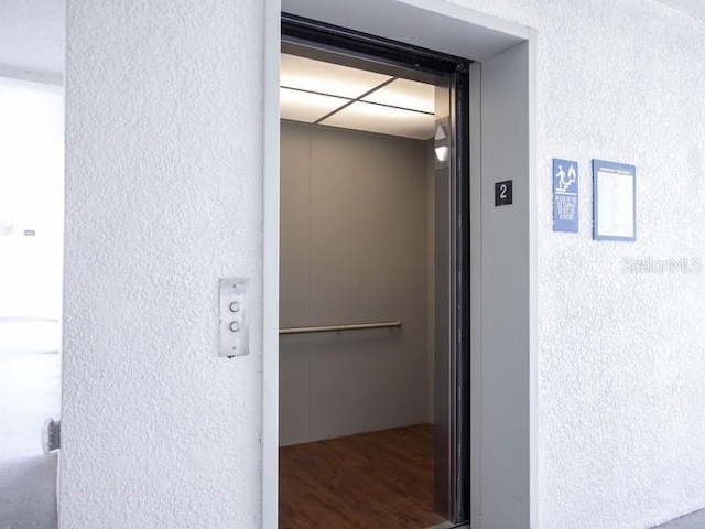 hallway featuring elevator and hardwood / wood-style flooring