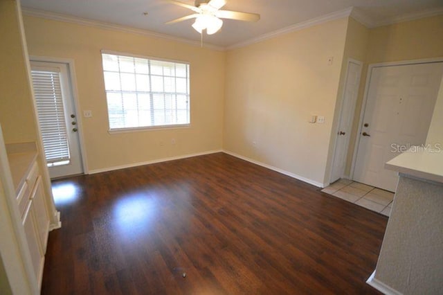 spare room featuring ceiling fan, dark wood-type flooring, and crown molding