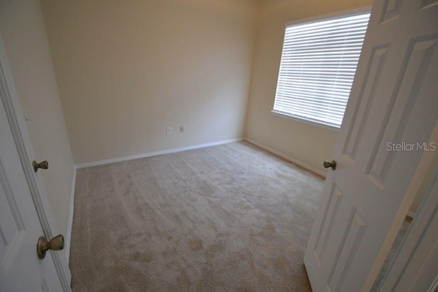 spare room featuring light carpet and a healthy amount of sunlight