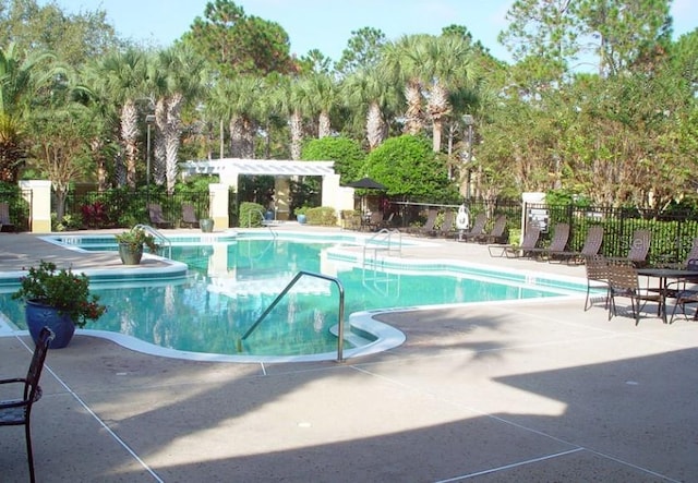 view of swimming pool featuring a jacuzzi and a patio