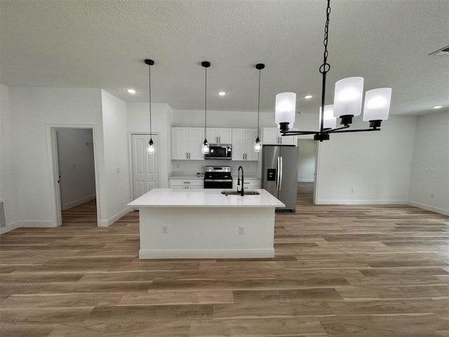 kitchen featuring decorative light fixtures, sink, hardwood / wood-style floors, and appliances with stainless steel finishes