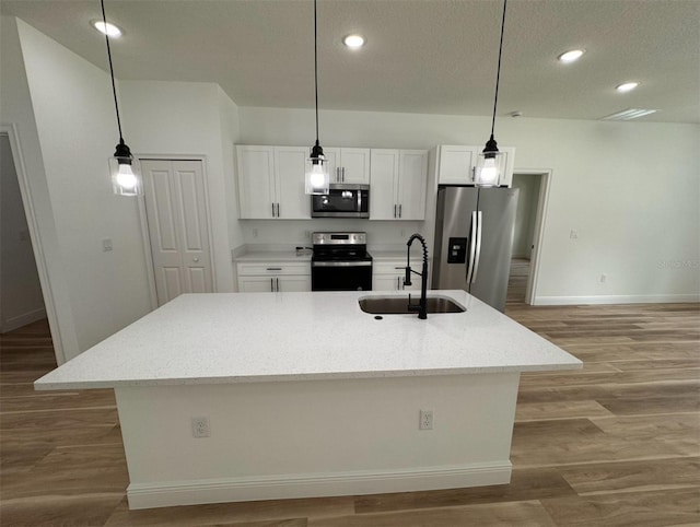 kitchen featuring stainless steel appliances, hardwood / wood-style floors, and white cabinetry