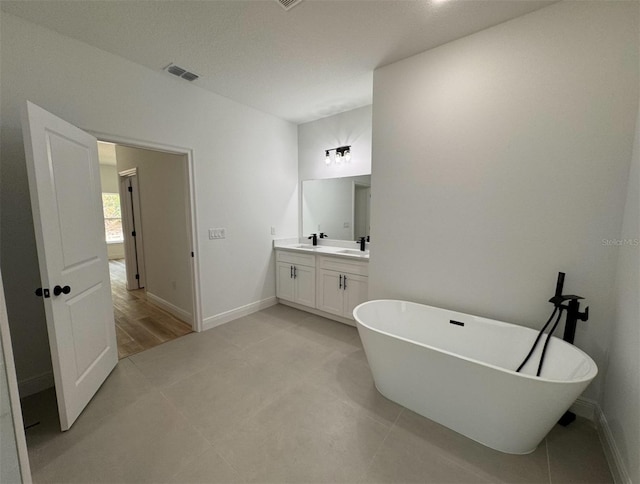 bathroom with a tub, hardwood / wood-style floors, and vanity