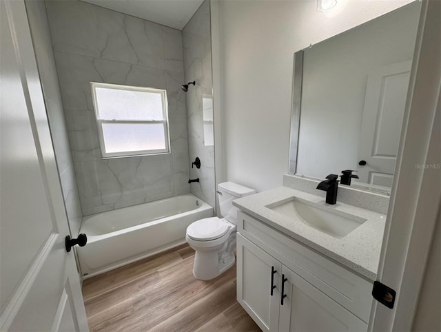 full bathroom with tiled shower / bath, hardwood / wood-style floors, oversized vanity, and toilet