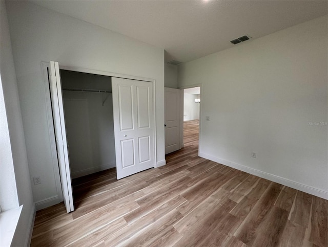 unfurnished bedroom featuring a closet and hardwood / wood-style flooring