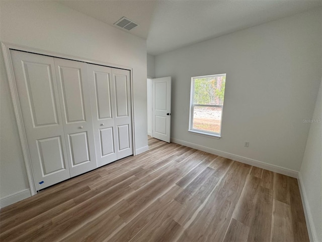 unfurnished bedroom featuring a closet and wood-type flooring