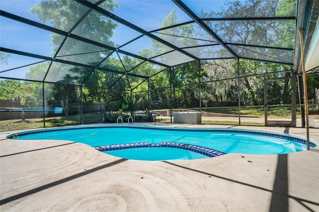 view of swimming pool featuring a patio and a lanai