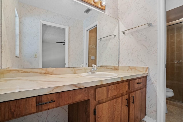 bathroom featuring toilet, tile floors, vanity, and a textured ceiling