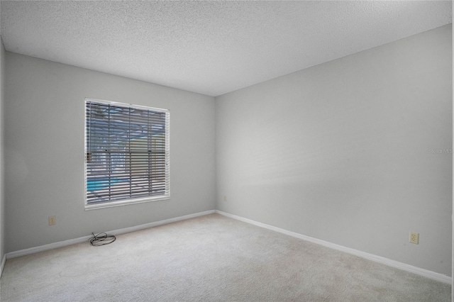 carpeted spare room with a textured ceiling