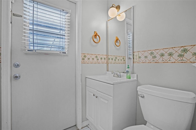 bathroom with vanity with extensive cabinet space and toilet