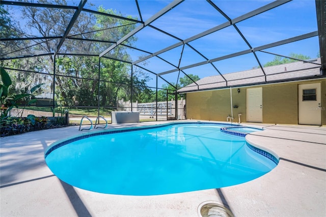 view of swimming pool featuring a patio area, an in ground hot tub, and glass enclosure