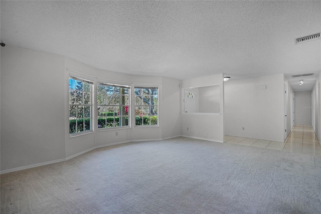 empty room featuring light colored carpet and a textured ceiling