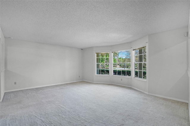 carpeted empty room with a textured ceiling