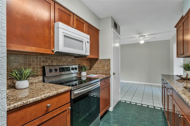 kitchen with light stone countertops, ceiling fan, tasteful backsplash, stainless steel electric range, and dark tile patterned flooring