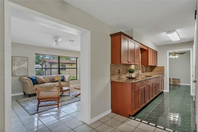 kitchen with tile patterned floors, ceiling fan, sink, and tasteful backsplash