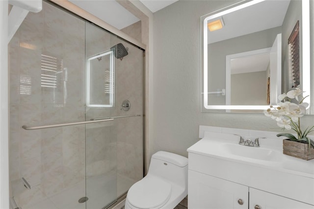 bathroom with vanity, toilet, and a shower with shower door