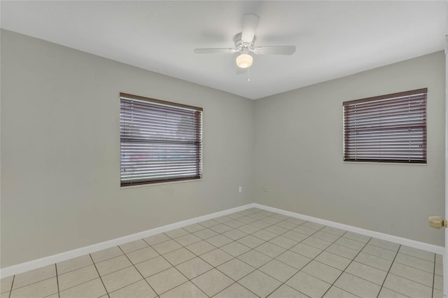 tiled spare room with ceiling fan