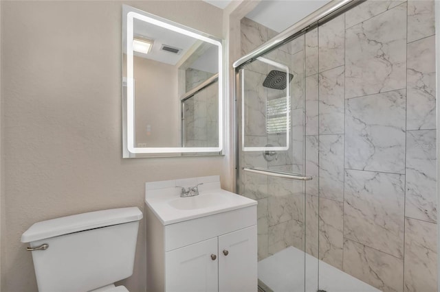 bathroom featuring a shower with door, vanity, and toilet