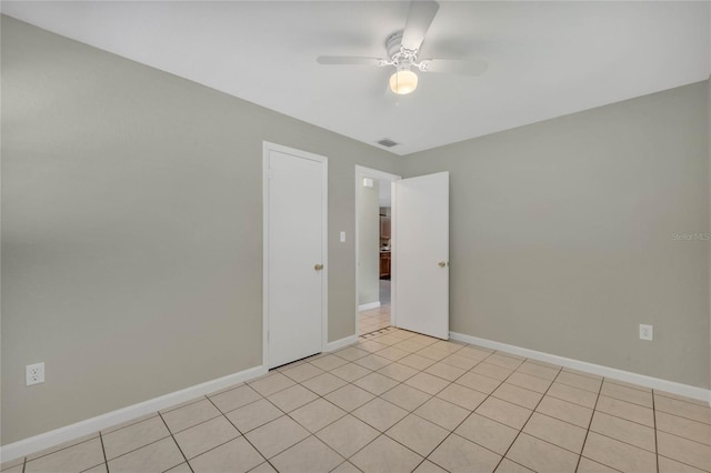 spare room with ceiling fan and light tile patterned floors