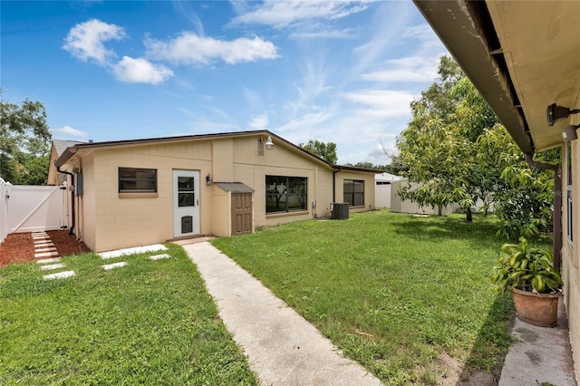 back of property with a lawn and central air condition unit