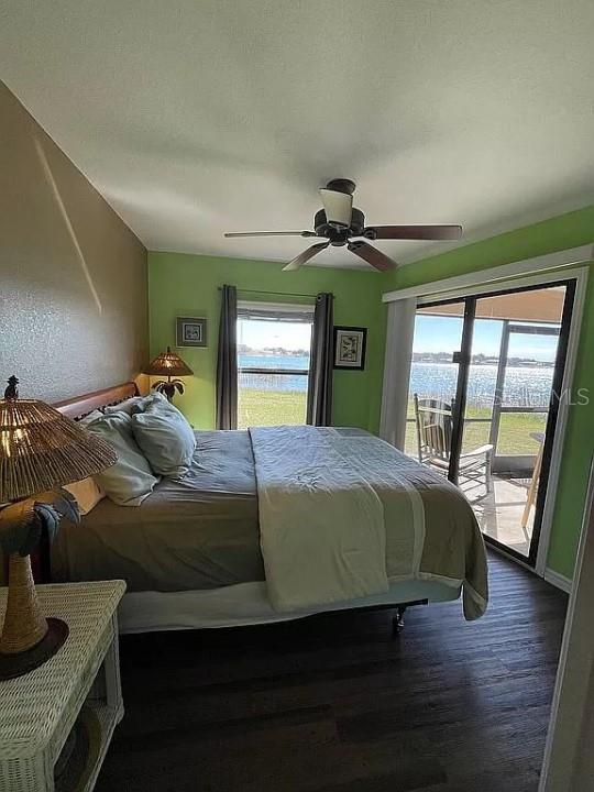 bedroom with dark hardwood / wood-style floors, ceiling fan, and access to outside