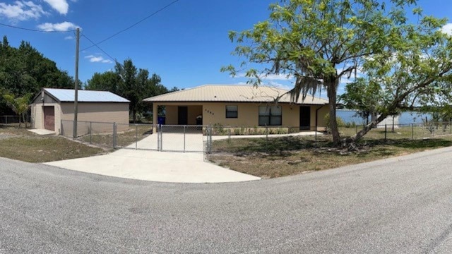 ranch-style home featuring a gate and fence