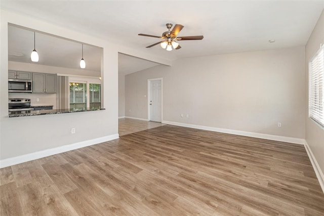 unfurnished living room with lofted ceiling, wood-type flooring, and ceiling fan