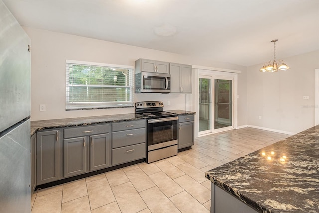 kitchen with a chandelier, decorative light fixtures, light tile flooring, appliances with stainless steel finishes, and gray cabinetry