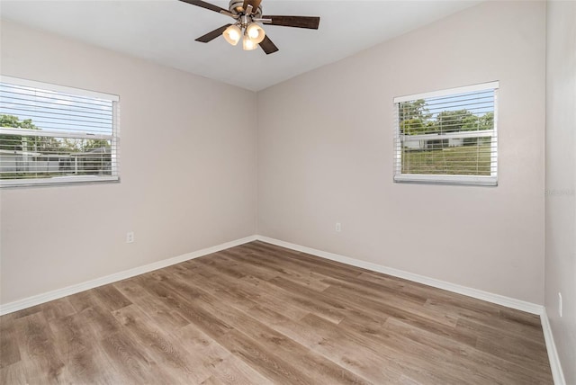 unfurnished room with ceiling fan, wood-type flooring, and a wealth of natural light