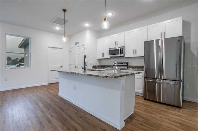 kitchen with white cabinetry, appliances with stainless steel finishes, dark wood-type flooring, and dark stone countertops