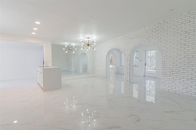 tiled empty room with an inviting chandelier