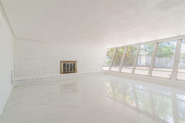 unfurnished living room featuring plenty of natural light, a textured ceiling, and light tile flooring