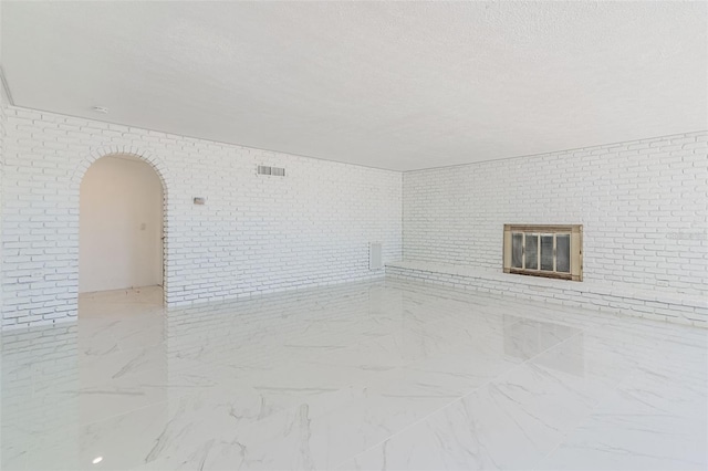 unfurnished living room featuring a textured ceiling and light tile flooring