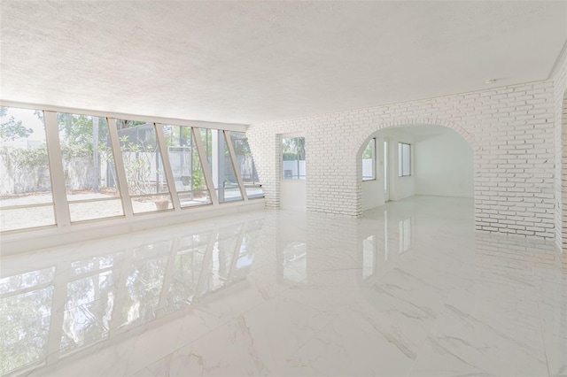 spare room featuring a textured ceiling and light tile flooring