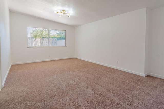 carpeted spare room featuring lofted ceiling