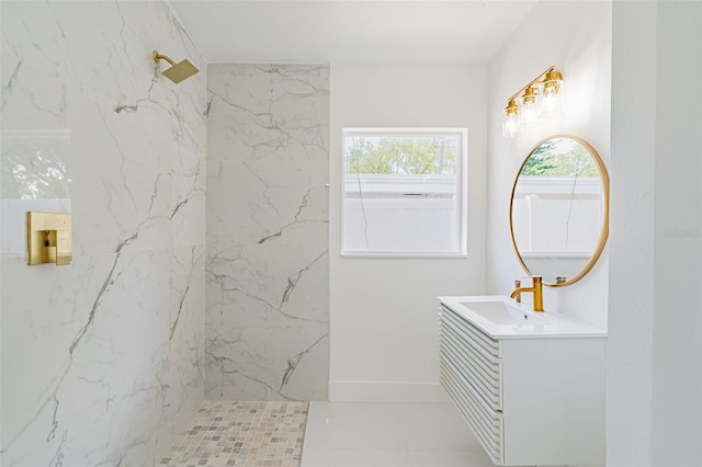 bathroom with a tile shower and vanity