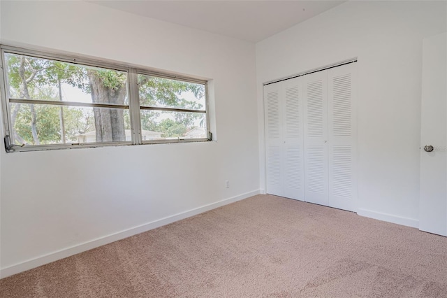 unfurnished bedroom featuring light colored carpet, a closet, and multiple windows