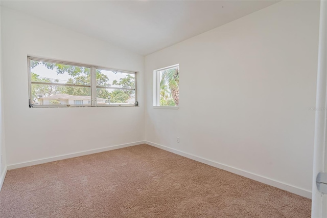 empty room with light carpet and vaulted ceiling