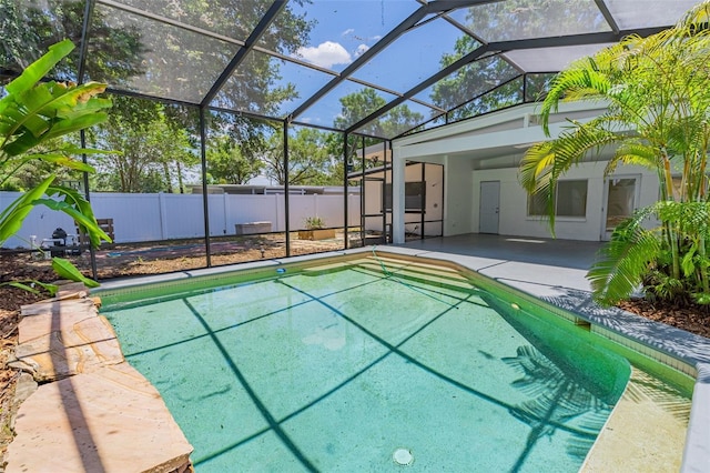 view of swimming pool featuring glass enclosure and a patio area