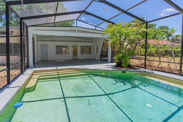 view of pool with glass enclosure and a patio