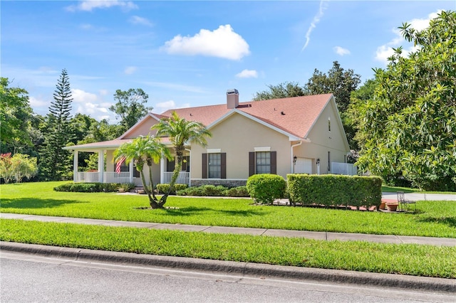 view of front of property with a garage, a front lawn, and a porch