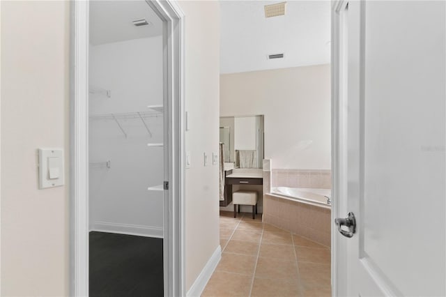 bathroom featuring tile patterned floors and tiled bath