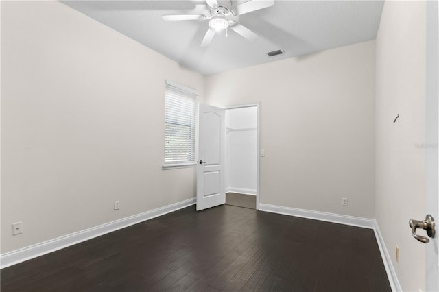 spare room with dark hardwood / wood-style floors and ceiling fan