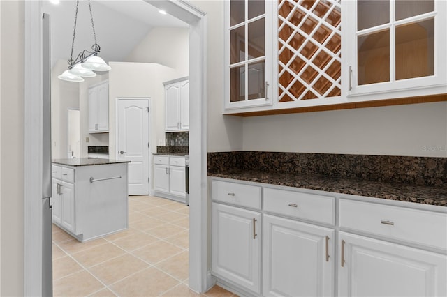 kitchen featuring vaulted ceiling, decorative light fixtures, white cabinetry, decorative backsplash, and light tile patterned floors