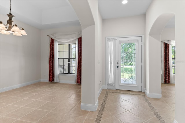 tiled foyer entrance featuring an inviting chandelier