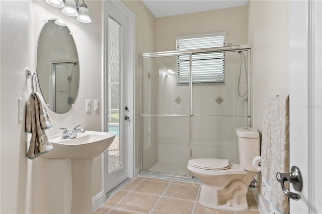 bathroom featuring tile patterned floors, toilet, and an enclosed shower