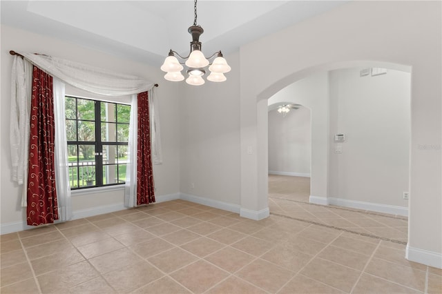 spare room featuring a chandelier and light tile patterned flooring