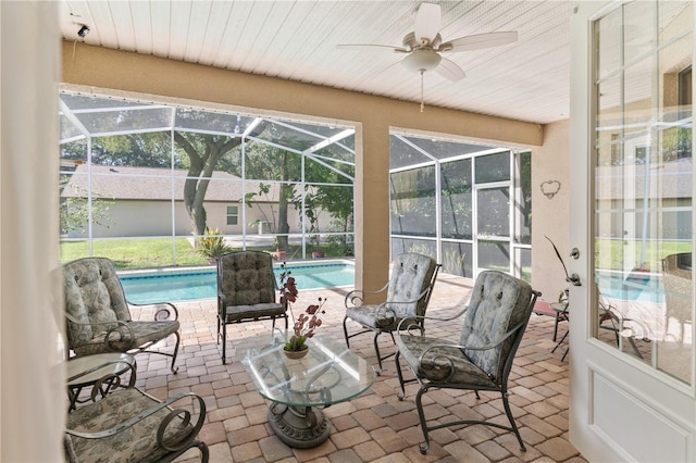 sunroom with a pool and ceiling fan