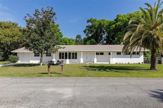 ranch-style home featuring a front lawn and a garage