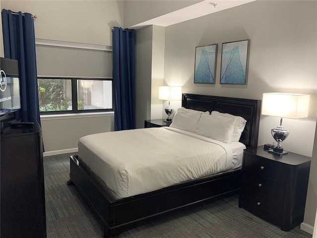 bedroom featuring dark colored carpet